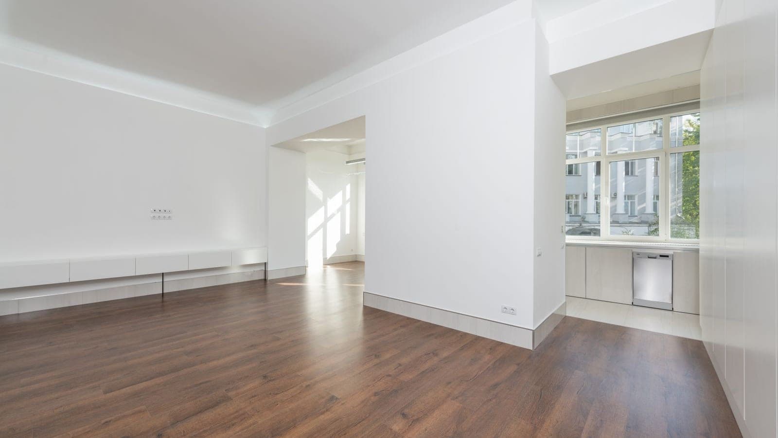 Leeg, wit geschilderd appartement met houten vloer, klaar voor bezichtiging