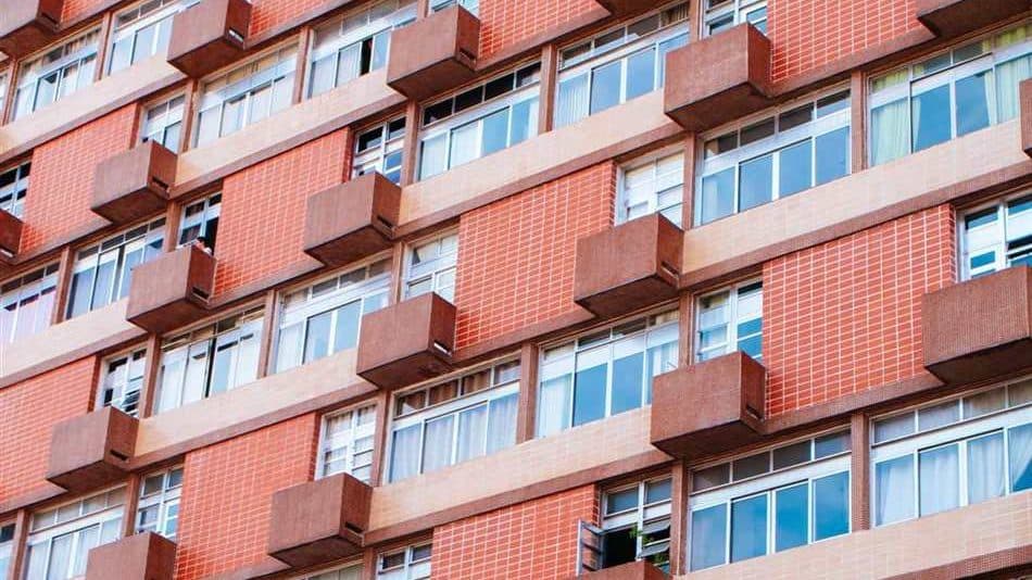Gevel van een Rotterdamse portiekflat met balkons, typisch VvE-schilderwerk