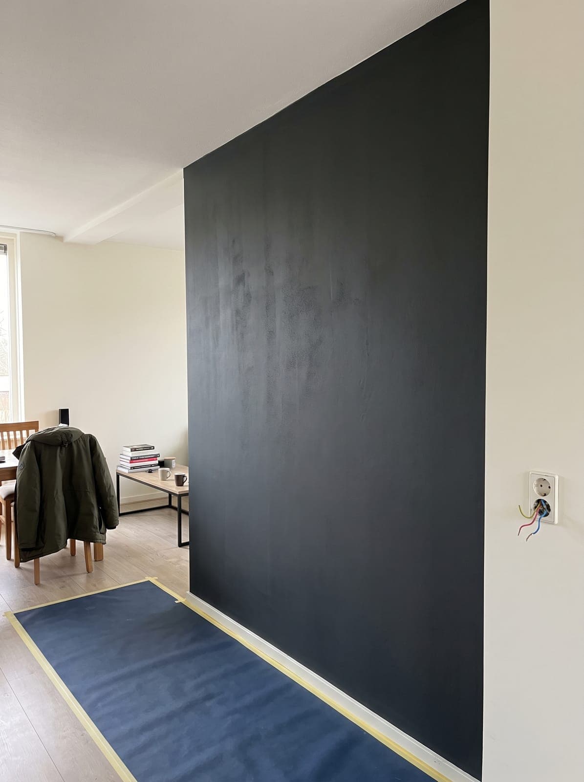 Strak geschilderde antracietkleurige wand in een woonkamer